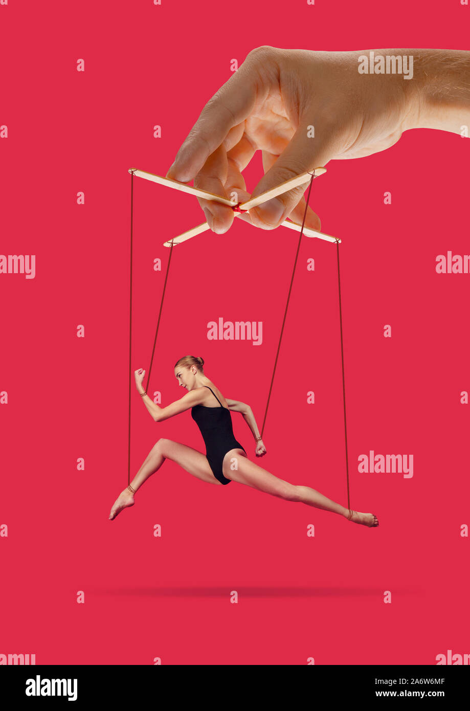 Hand Puppet Mocking Woman like a puppet in somebodies hands on pink background. Concept of ...
