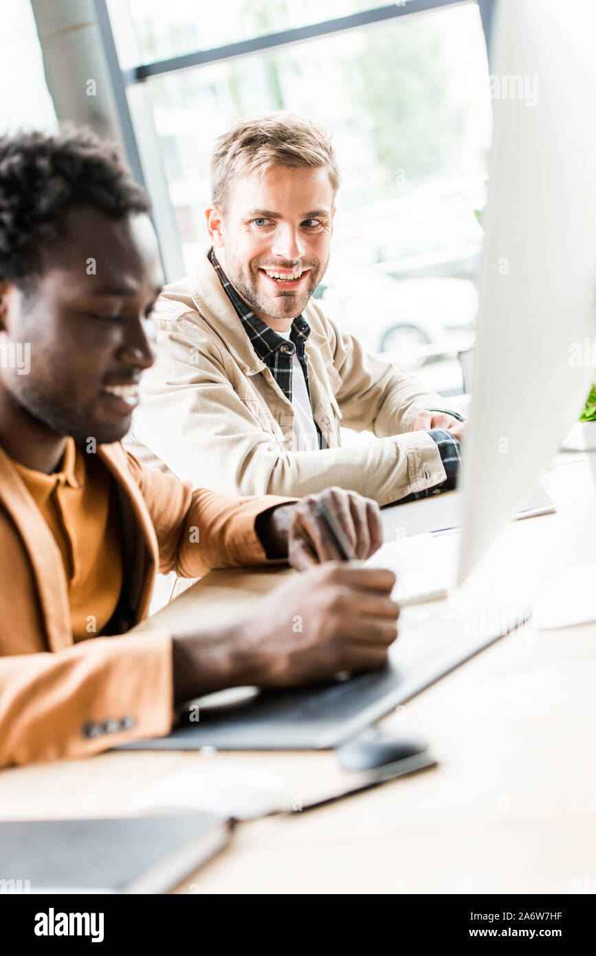 selective focus of two multicultural businessmen working together in office Stock Photo