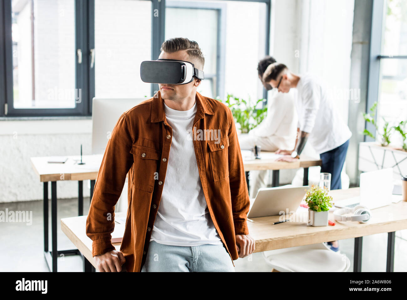 young businessman using vr headset while multicultural colleagues working in office Stock Photo