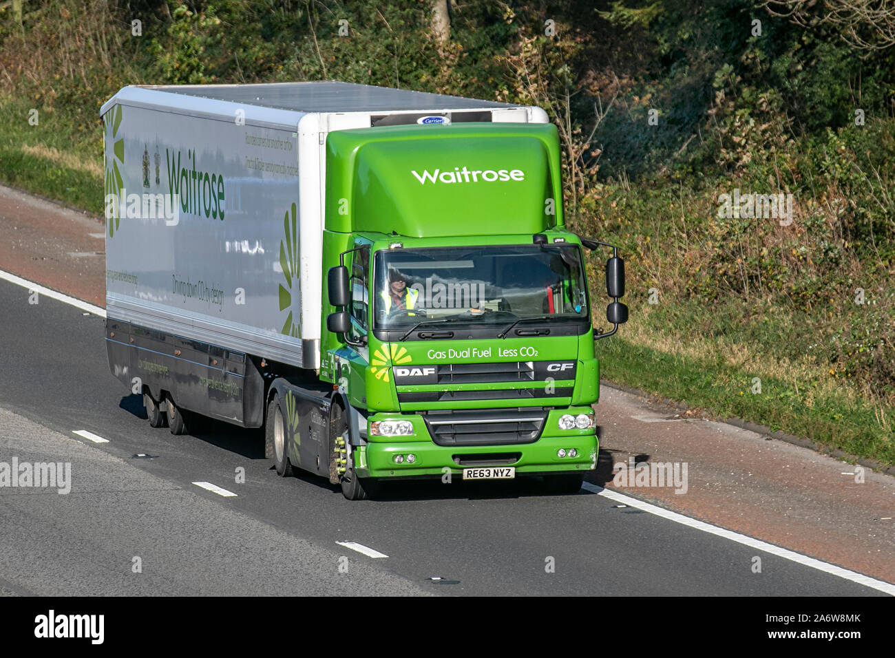 Waitrose green & white food truck delivery; Haulage delivery trucks, lorry, transportation, truck, cargo, vehicle, delivery, commercial transport, industry, supply chain freight, on the M6 at Lancaster, UK Stock Photo