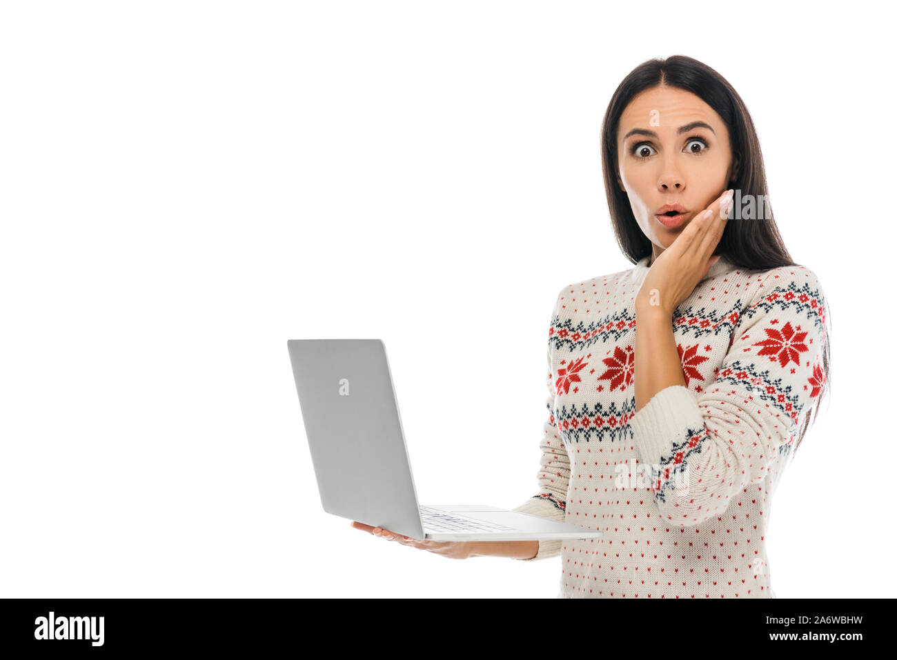 surprised woman looking at camera while holding laptop isolated on white Stock Photo