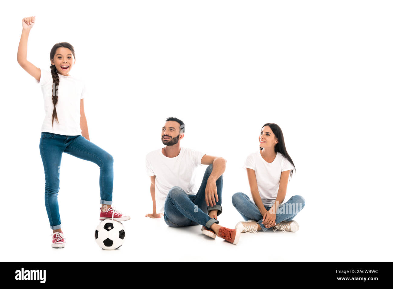 happy kid with hand above head standing near football and parents on white Stock Photo