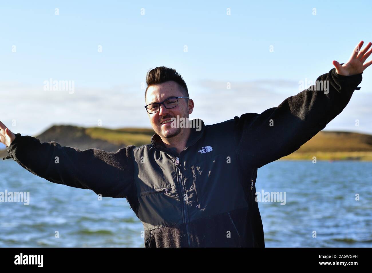 Lake Myvatn, Iceland. A tourist enjoys the shoreline along the cool, blue waters of Lake Myvatn in Northern Iceland. Stock Photo