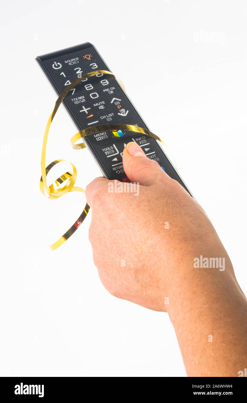 hand holding a remote control in a festive gold ribbon on white
