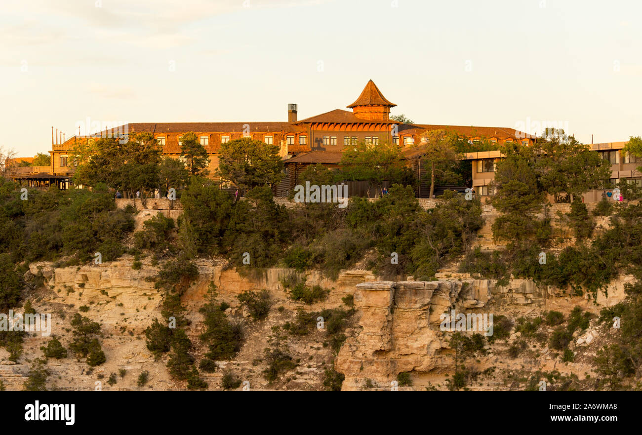 El Tovar Hotel at the Grand Canyon from a distance atop the steep cliffs of the canyon with a blue sky Stock Photo