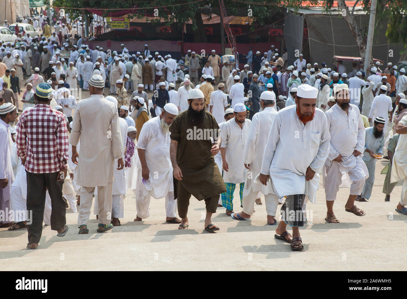 Muslim men answer the call to prayer and walk towards the entrance of the Shahi Igdah Mosque in Delhi Stock Photo