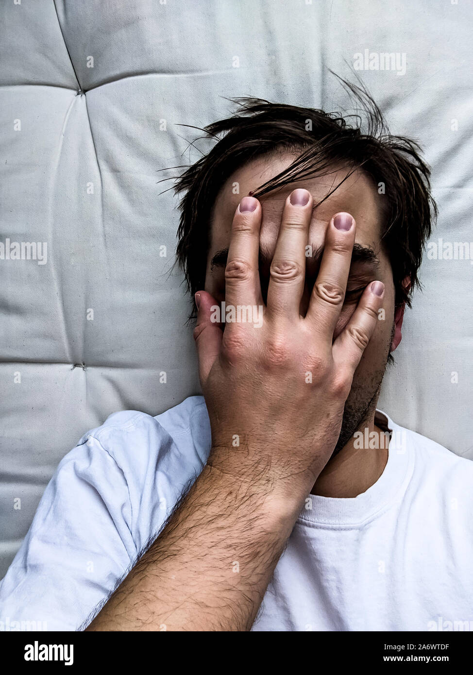 Exhausted Young Man on Bed - Frustrated Man Stock Photo