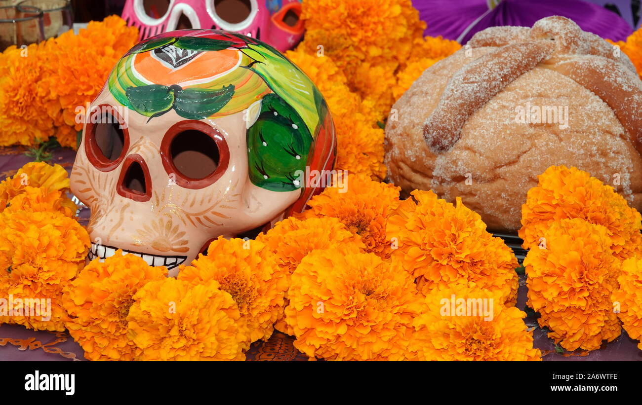 Sugar skull, marigolds and pan de muerto in a  Day of the Dead altar display (ofrenda) Stock Photo