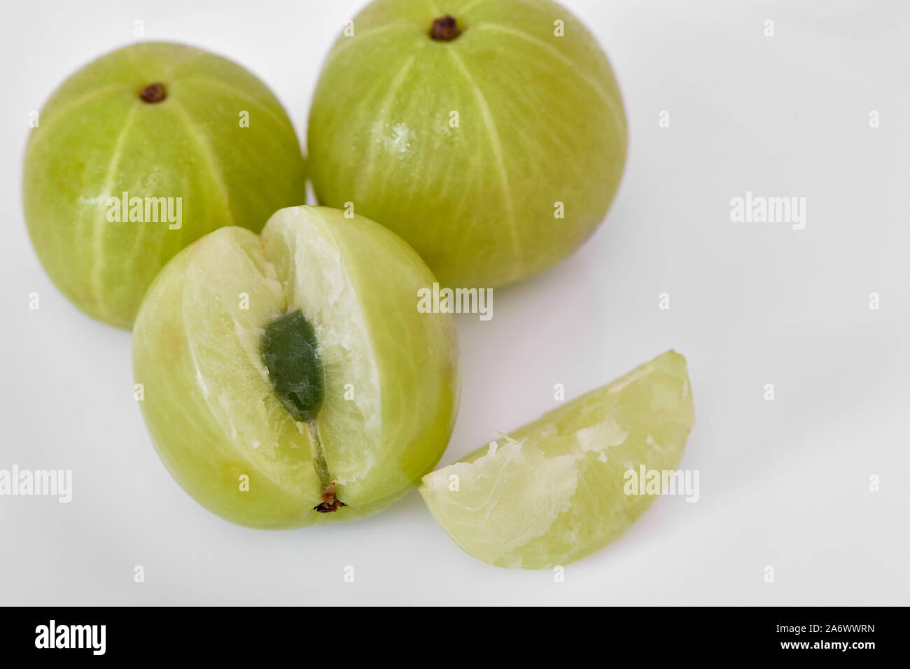 Whole and sliced gooseberries or Amala (Phyllanthus emblicxa) on a  white background Stock Photo