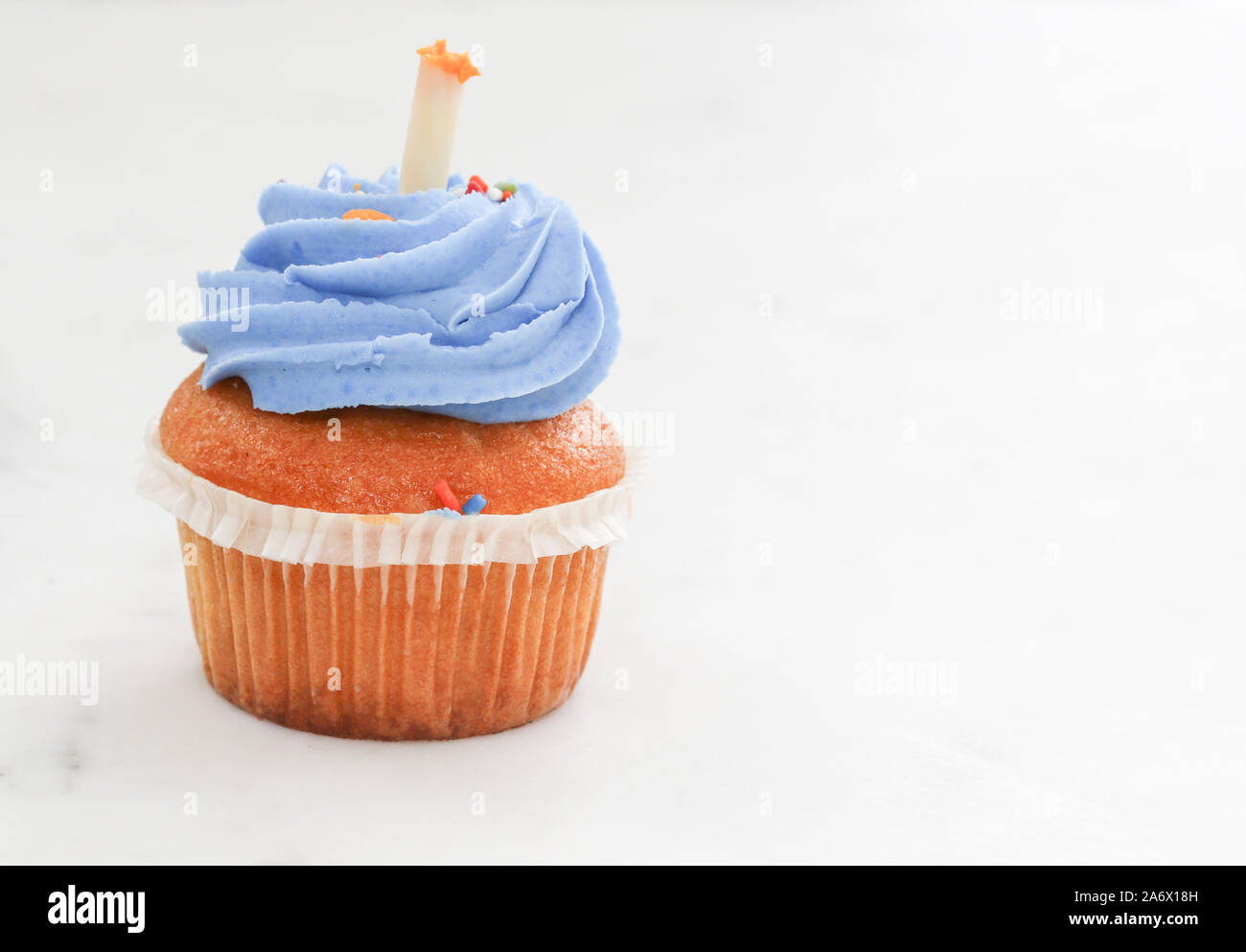 Teal birthday cupcake with butter cream icing isolated on white. - Image Stock Photo