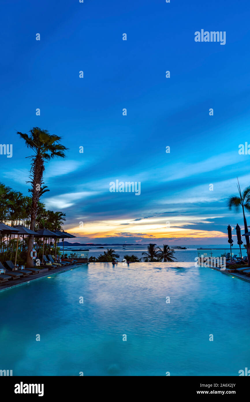 Hotel infinity swimming pool at sunset, Pattaya, Chon Buri, Thailand Stock Photo