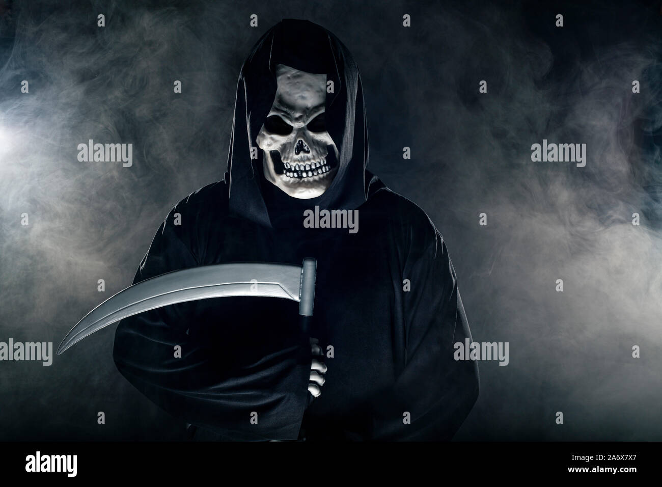 Scary looking grim reaper ghost wielding a scythe or sickle coming out