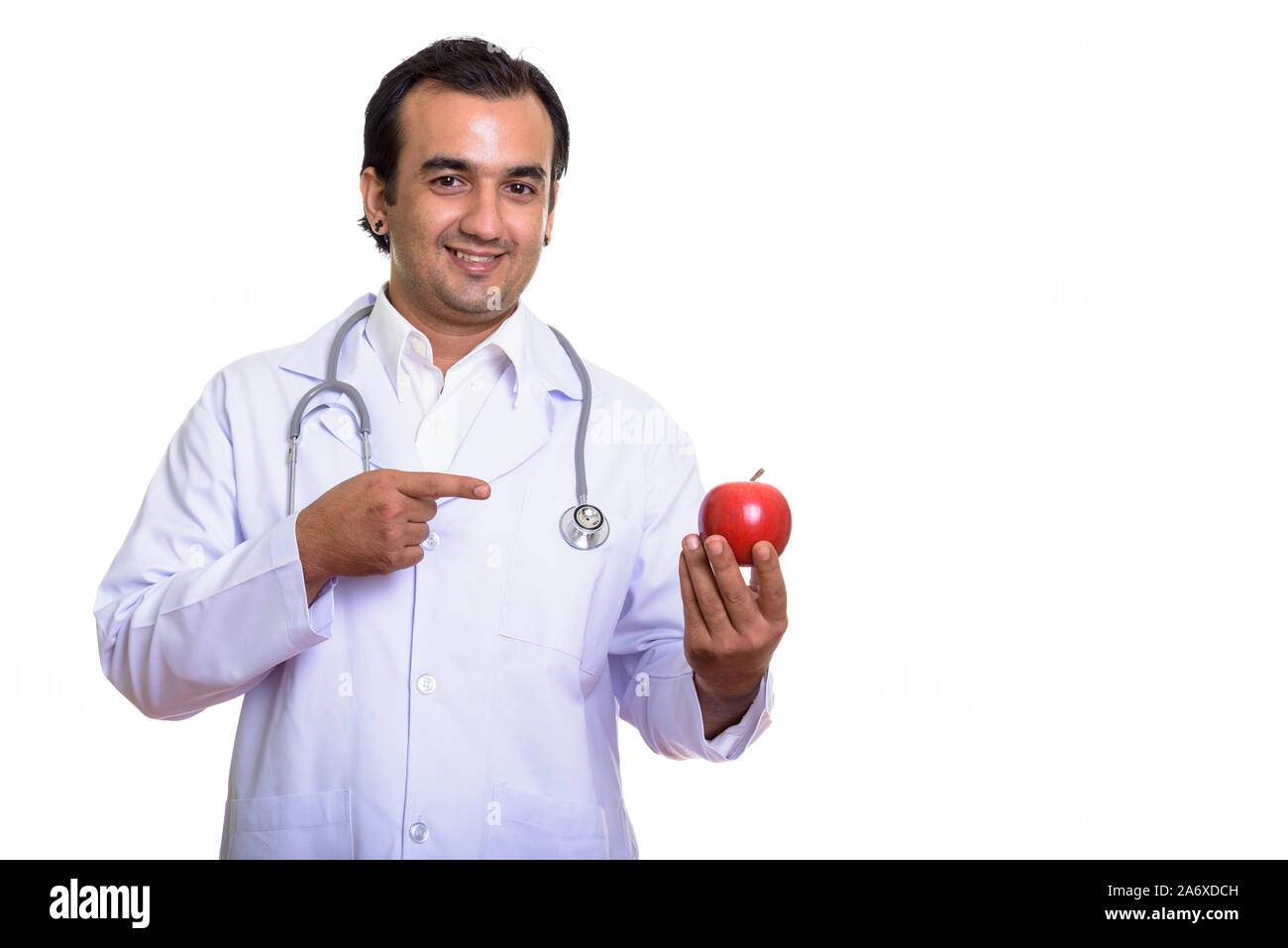Portrait of happy Persian man doctor with red apple Stock Photo