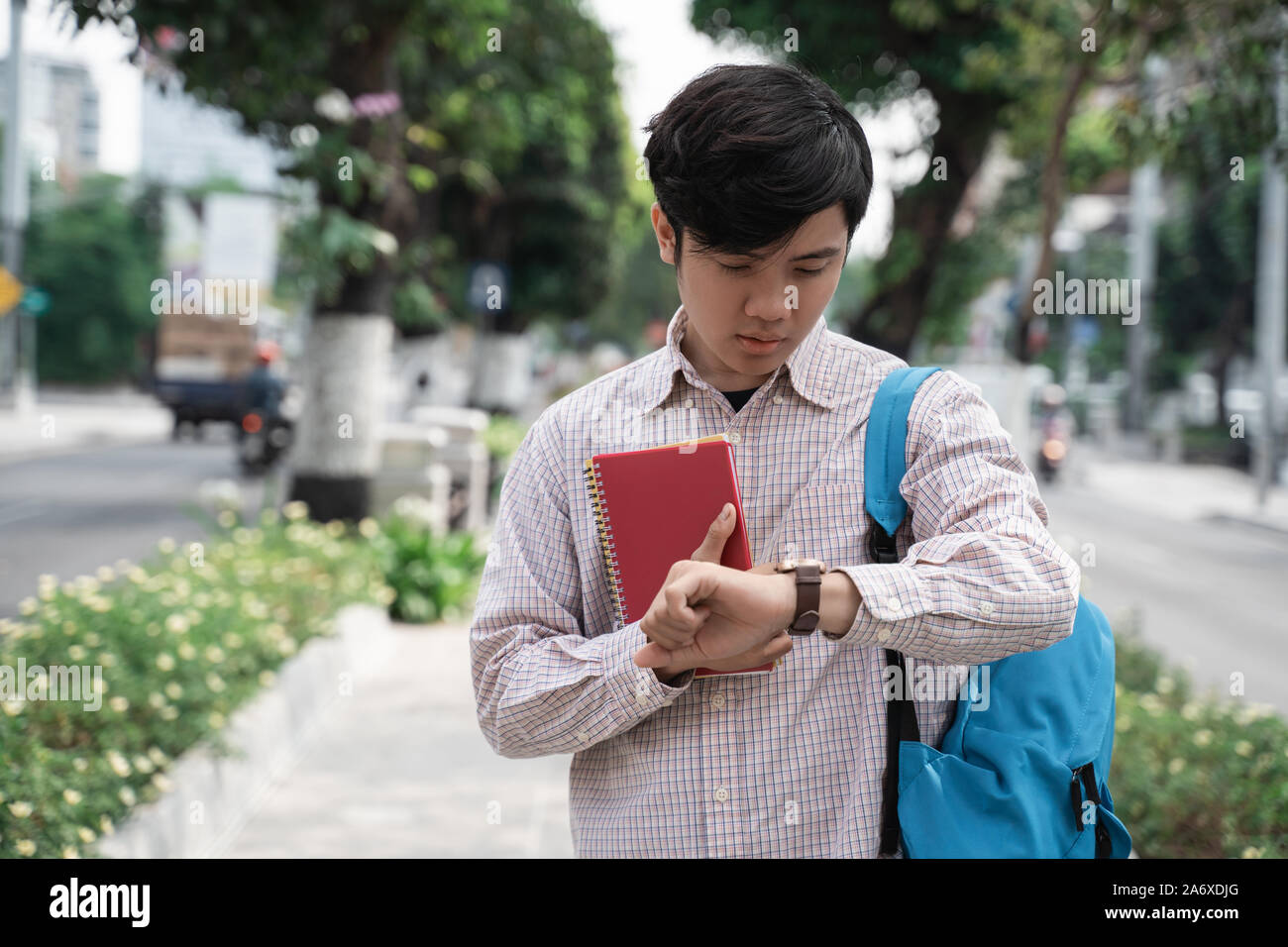 asian student look at watch in a hurry Stock Photo - Alamy