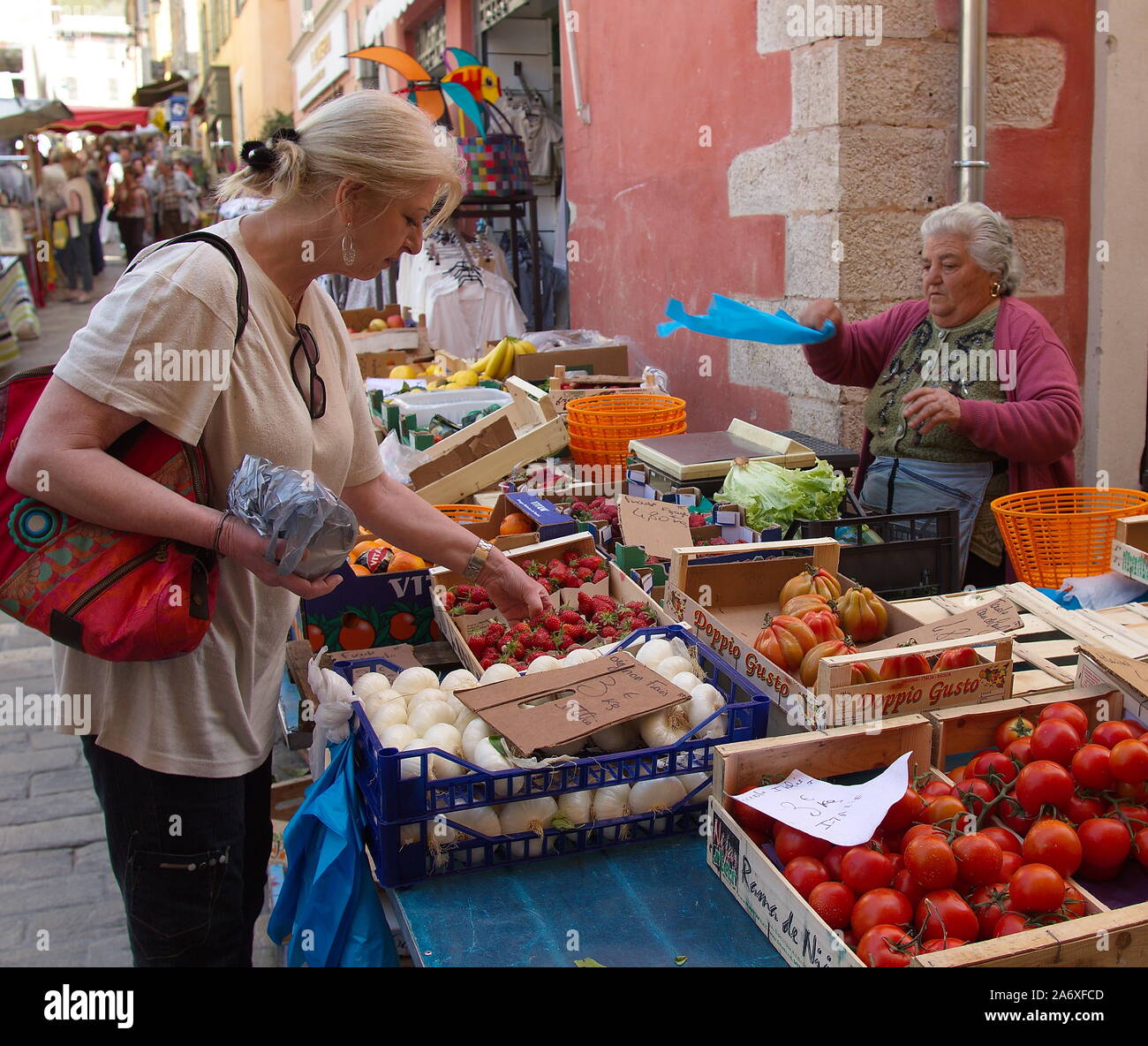 Customer choosing vegetables at a stall in the market square of Valbonne, Riviera, Provence, France Stock Photo