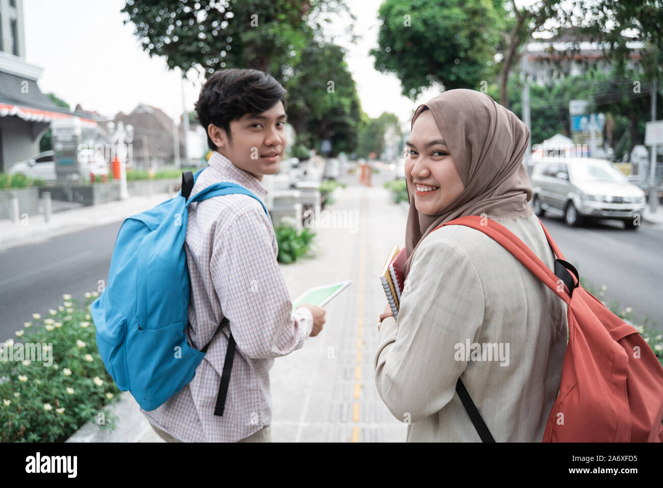 portrait of two teenage student walk away while looking back Stock ...