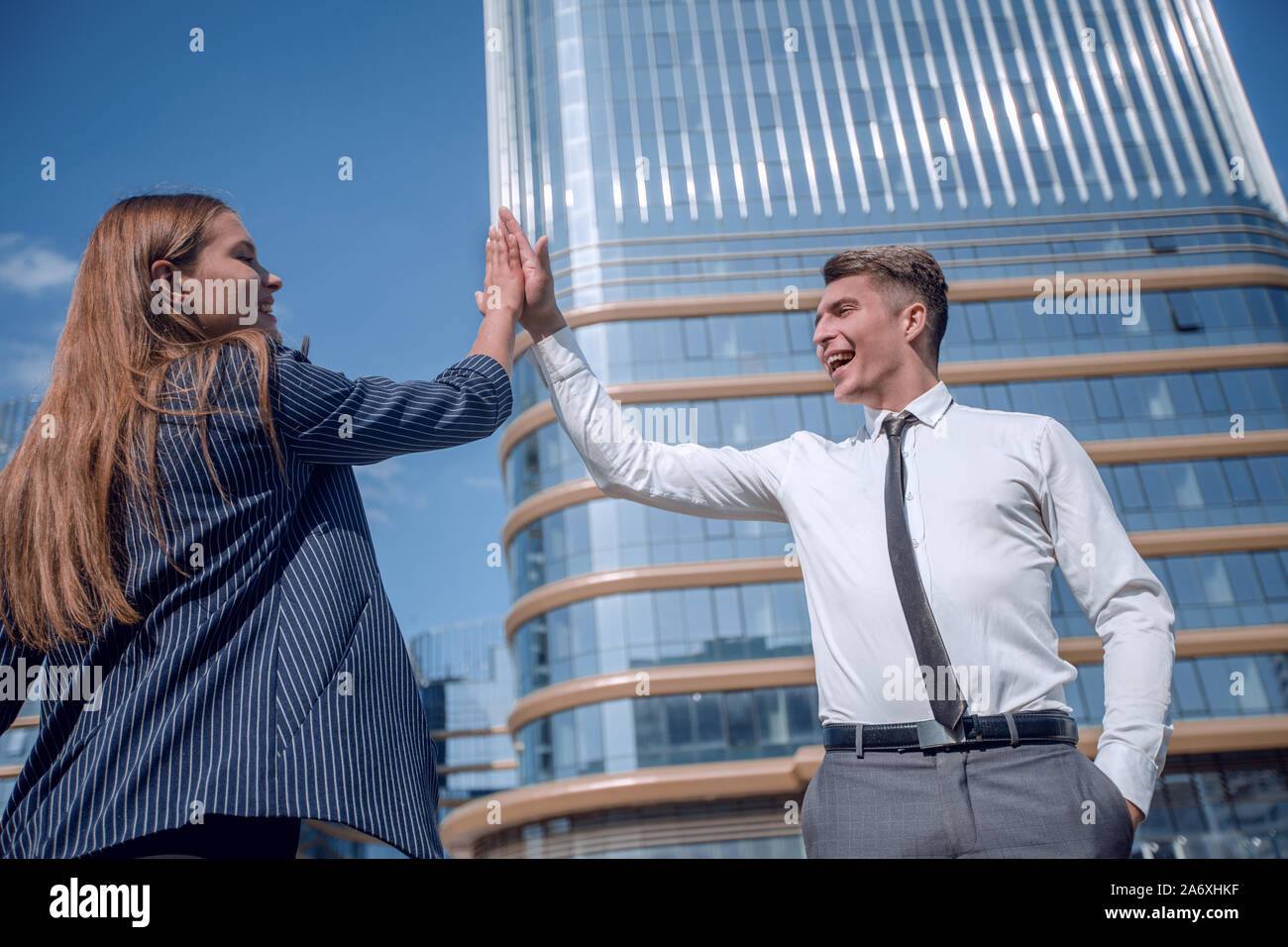 happy young employees giving each other a high five Stock Photo - Alamy
