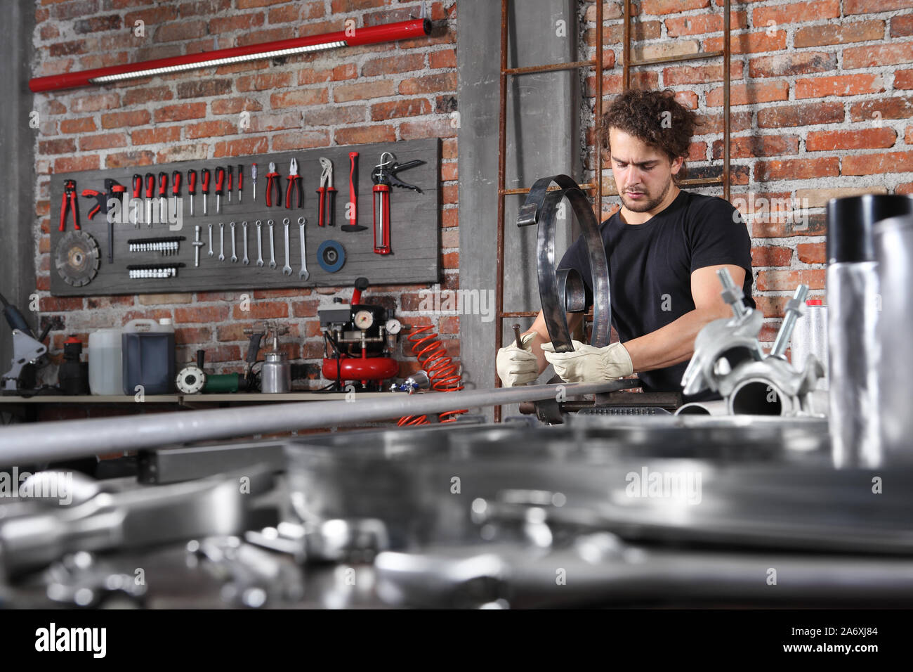 man work in home garage with bench grip vise fix a metal on