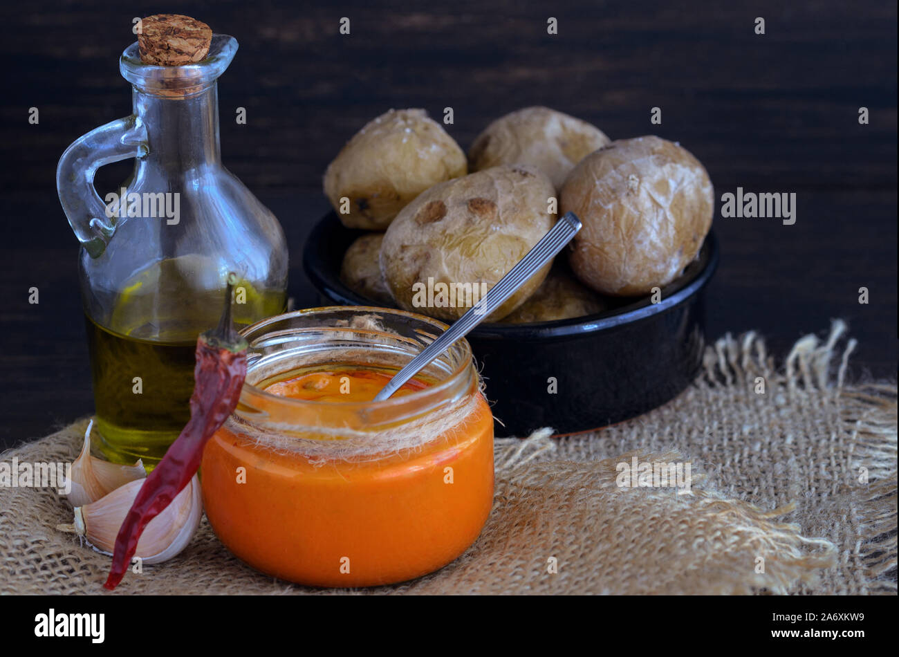 Local Canary Islands dish, Papas Arrugadas (wrinkly potatoes) with Mojo picon (red sauce). Stock Photo