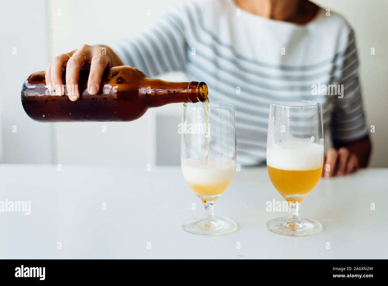 Woman pouring a refreshing beer in a glass. Stock Photo