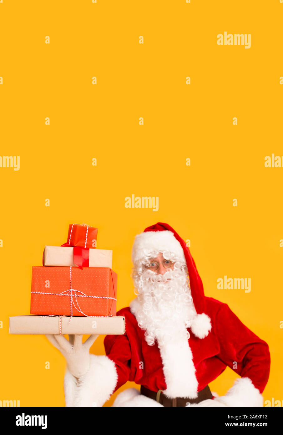 Santa Claus with gift boxes on orange background Stock Photo