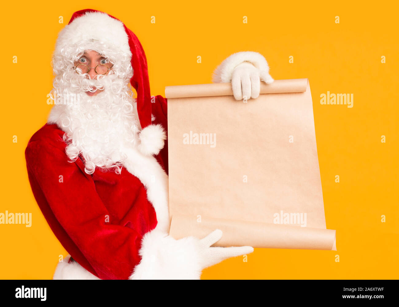 Santa Showing Big Sheet Of Paper With Copy Space For Wishes Stock Photo Santa showing big sheet of paper with copy space for wishes stock photo