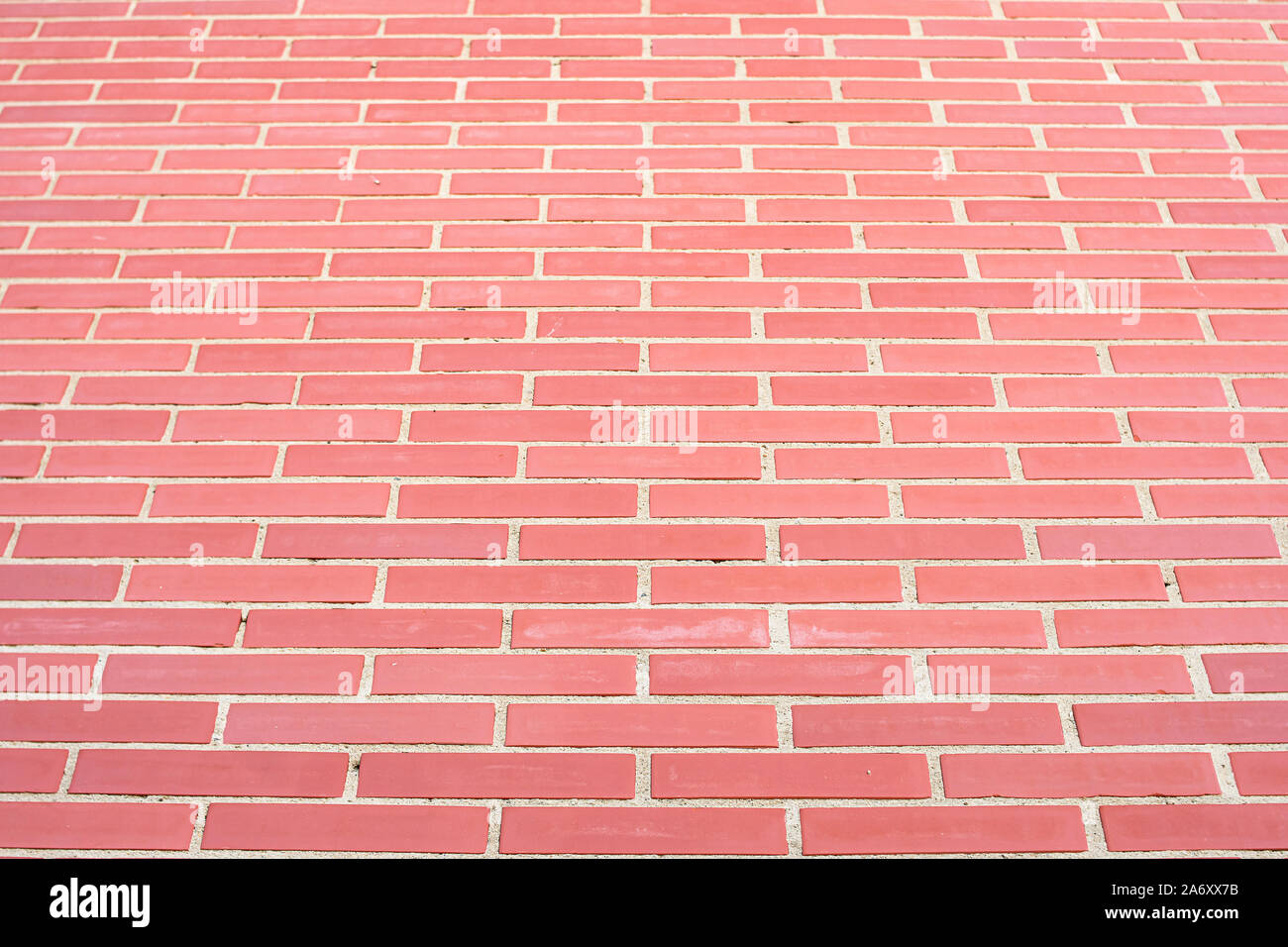 Wall of bricks and cement, reddish in color, forming a high and uniform wall Stock Photo