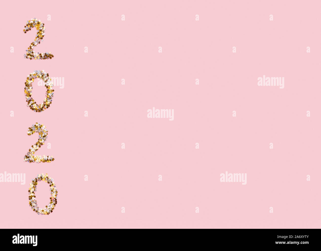 2020 text of gold confetti on pink background Stock Photo