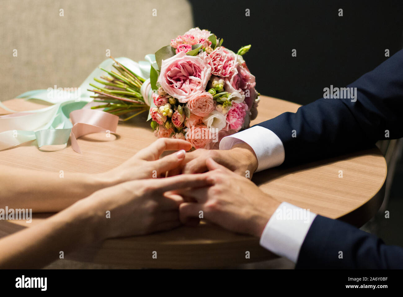 Wedding bouquet and hands of the bride and groom Stock Photo - Alamy