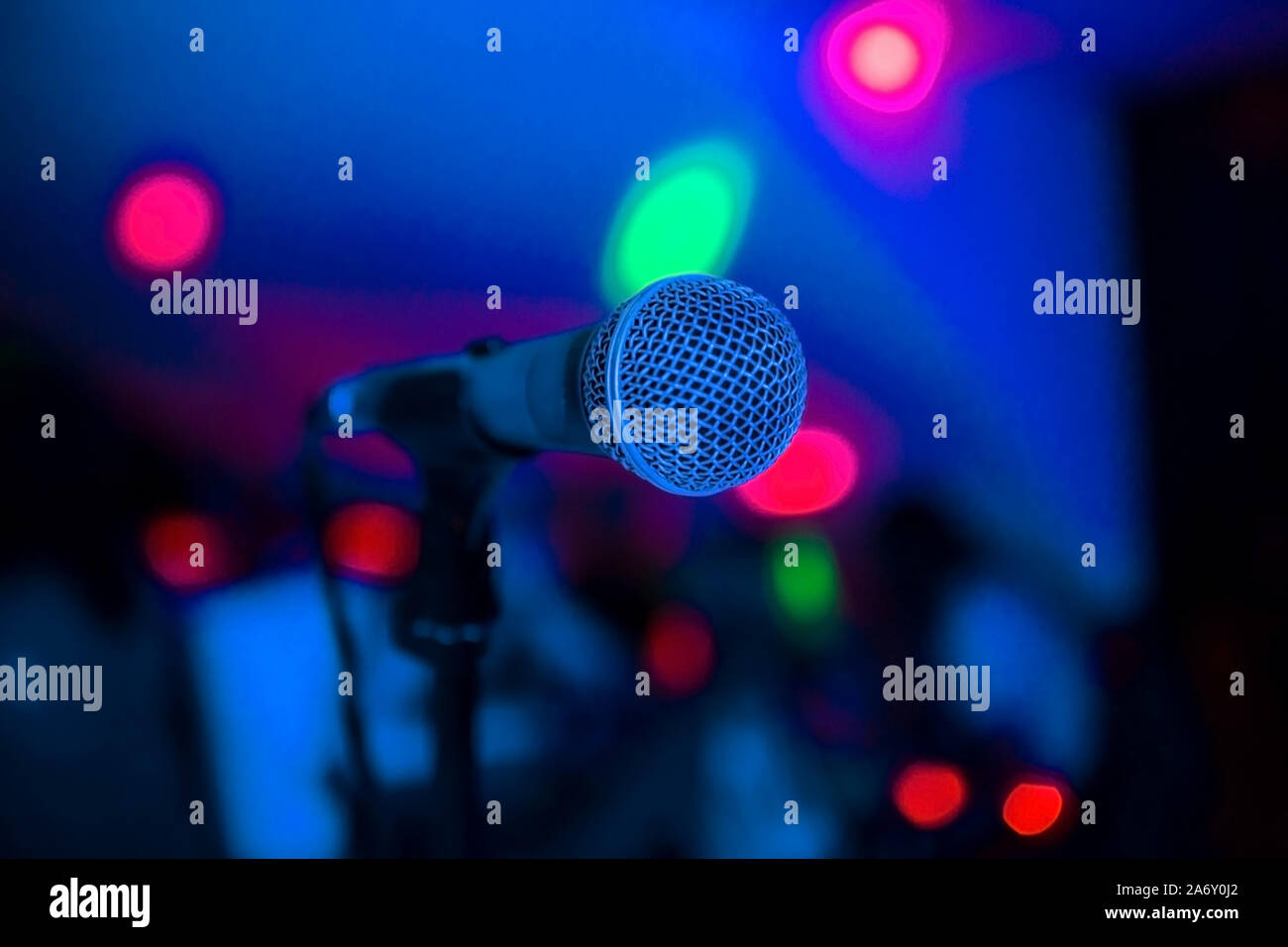 Microphone stands on stage in a Bright club light shines on