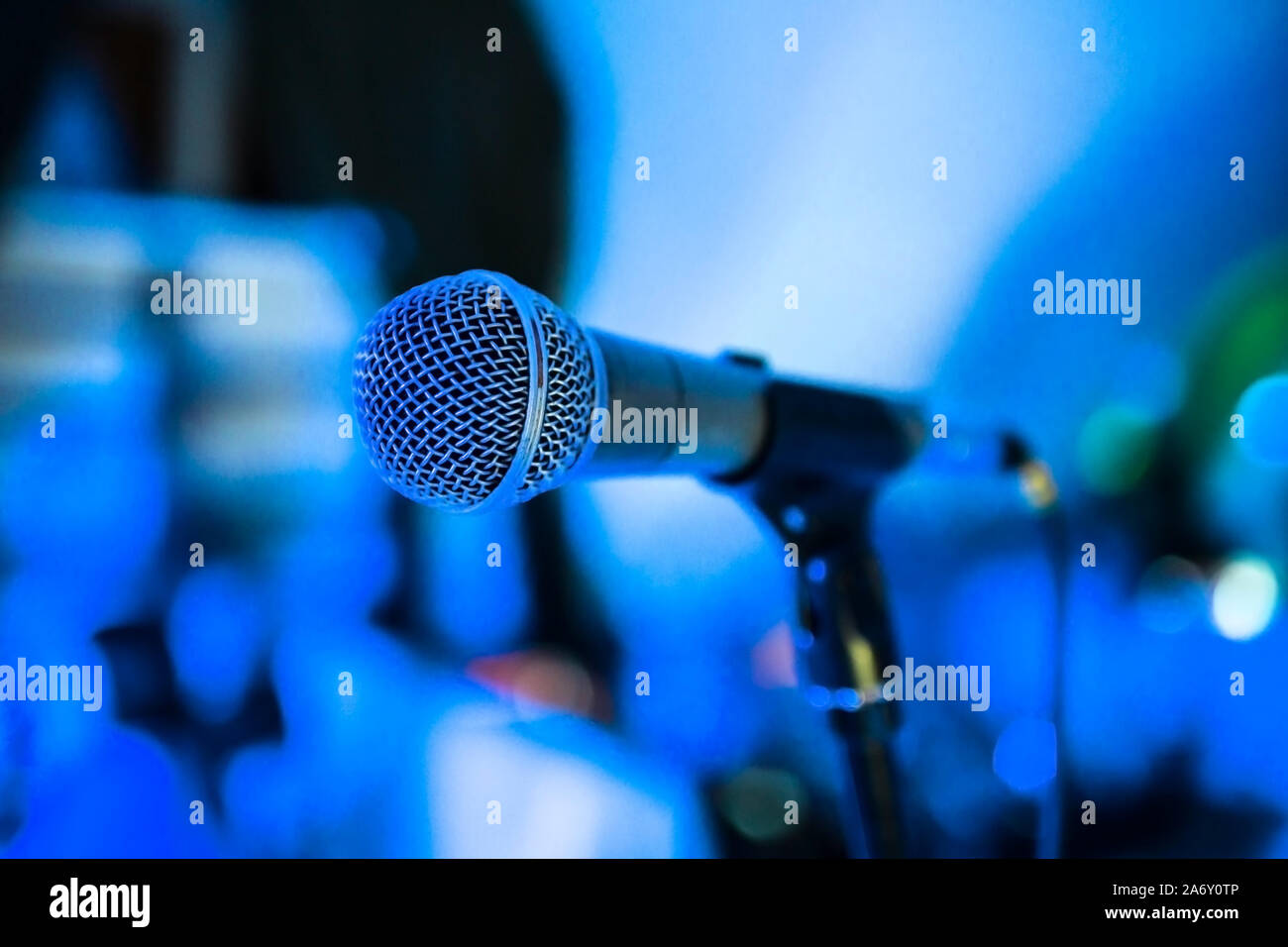 Microphone stands on stage in a Bright club light shines on