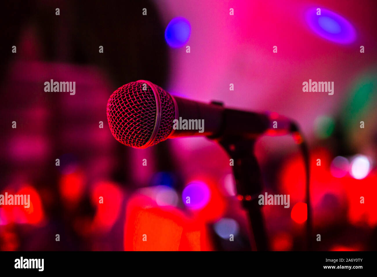 Microphone stands on stage in a Bright club light shines on