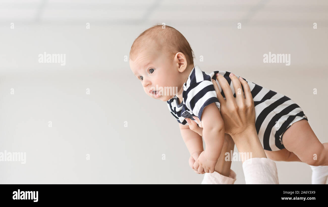 Portrait of funny newborn baby lifted in air by mother Stock Photo - Alamy