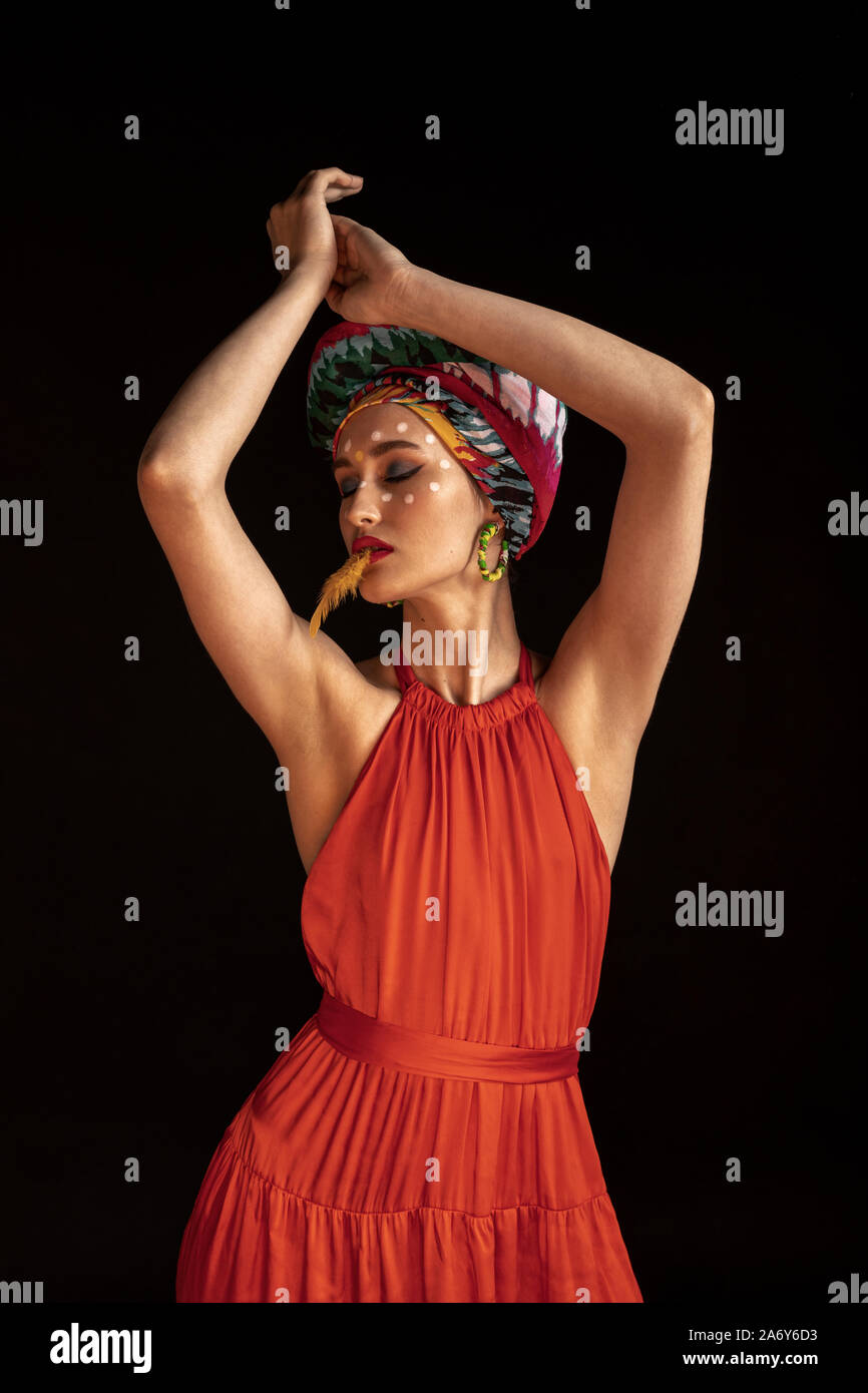 girl with a feather and a red dress Stock Photo - Alamy
