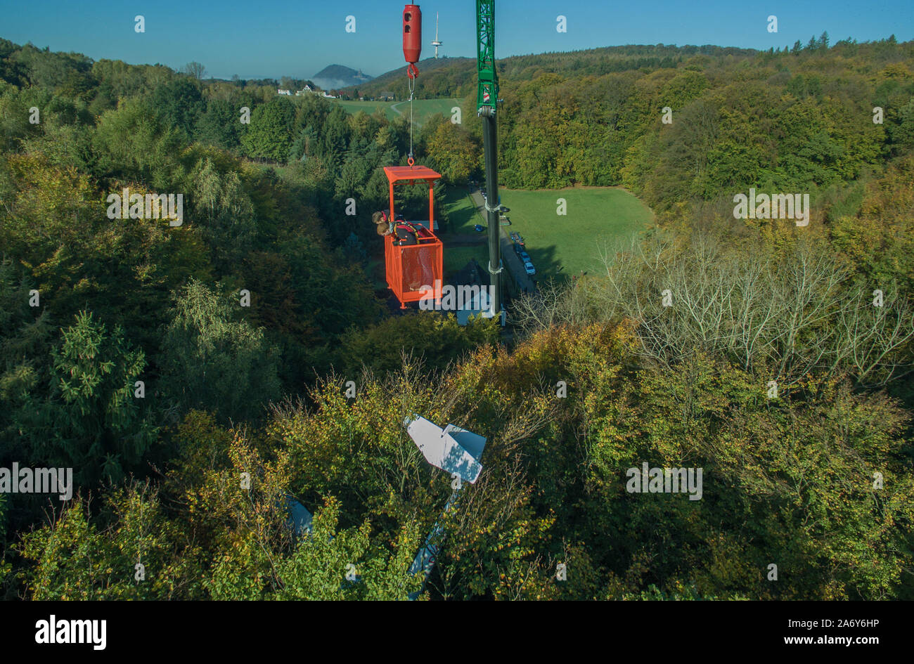 Porta Westfalica, Germany. 29th Oct, 2019. An injured glider, which is to be salvaged today, hangs in the crowns of trees. The plane was to be forced to land in the forest area on 12.10. and got caught in the treetops at a height of 35 metres. The pilot and his companion could be freed unharmed with a helicopter. (Aerial photograph with drone) Credit: Friso Gentsch/dpa/Alamy Live News Stock Photo