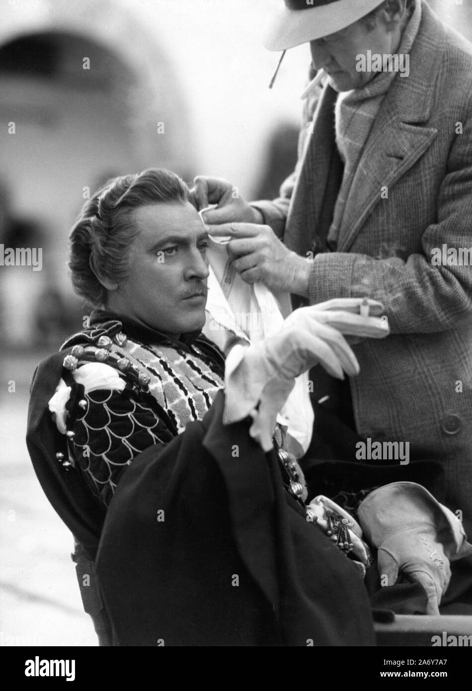 JOHN BARRYMORE in costume as Mercutio on set candid with make-up man during  filming ROMEO AND JULIET 1936 director GEORGE CUKOR play WILLIAM  SHAKESPEARE costumes ADRIAN and OLIVER MESSEL producer IRVING THALBERG
