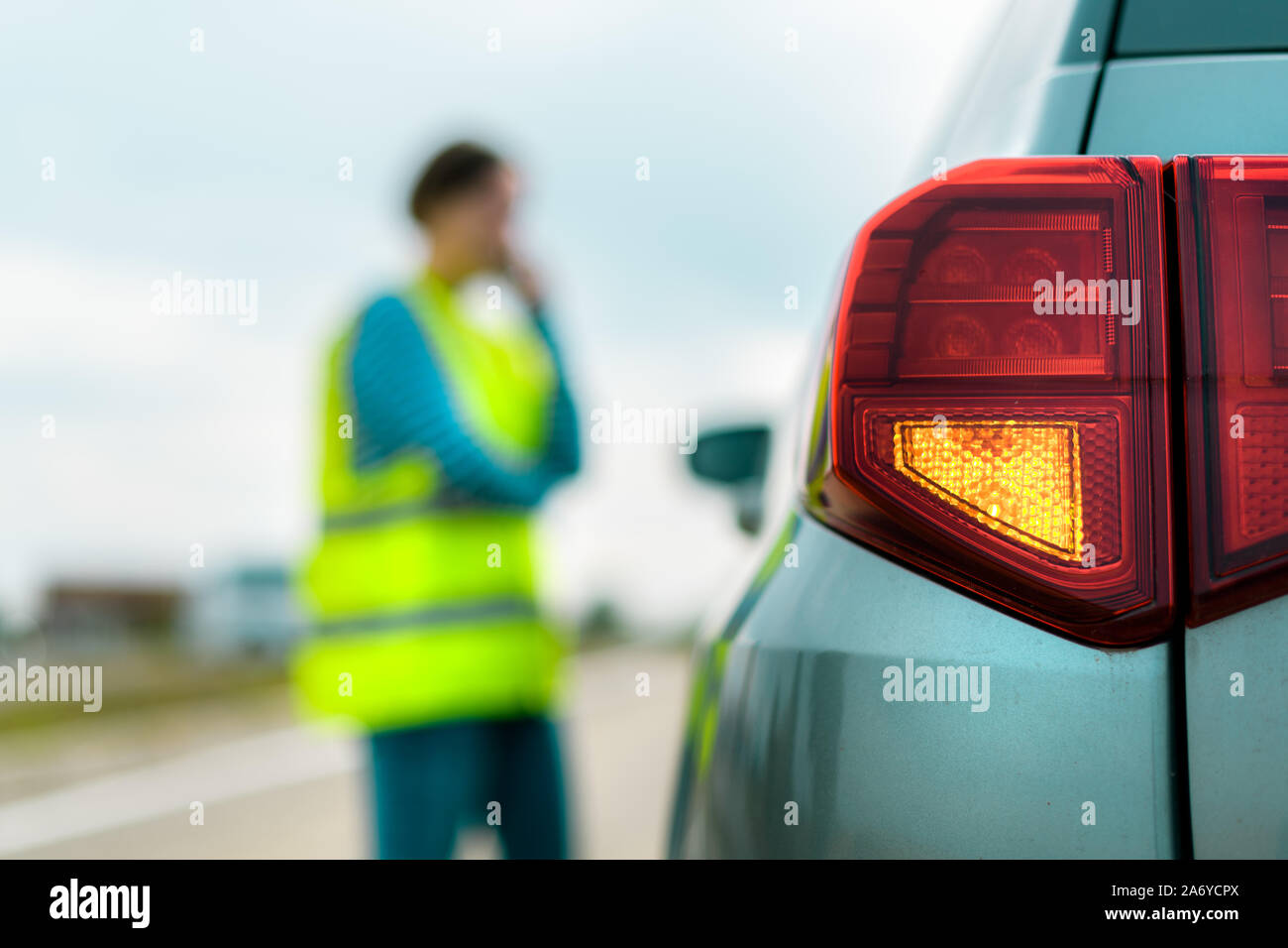 Vehicle breakdown on the road, woman using phone to ask for help and roadside assistance Stock Photo