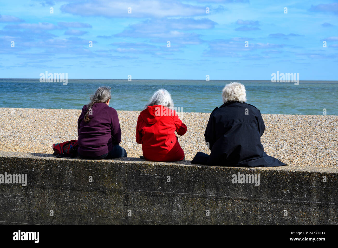 Ladies sitting on the sea wall Aldeburgh Suffolk England Stock Photo