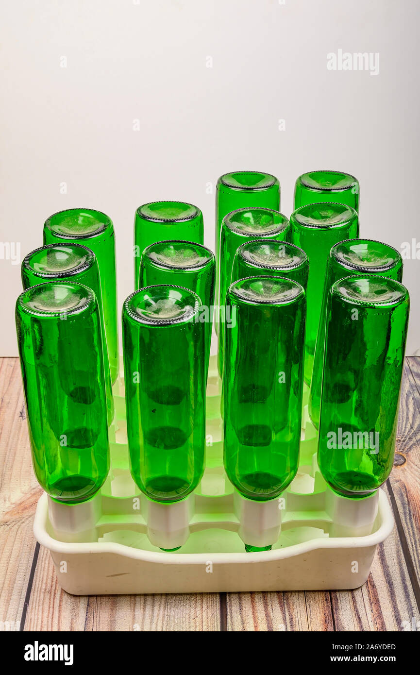 Empty wine bottles in a plastic dryer on the table Stock Photo