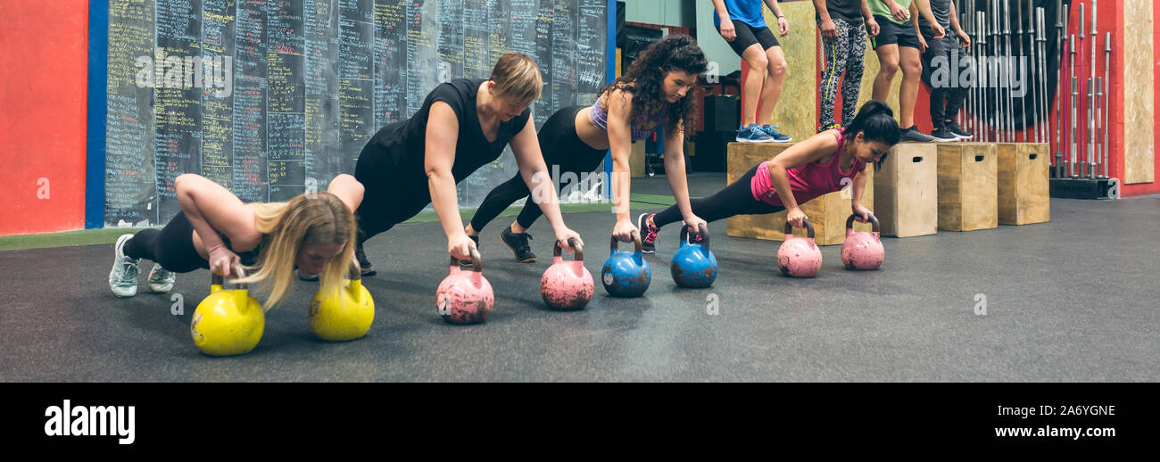 Women doing push ups training arms with trx straps in gym Stock Photo -  Alamy