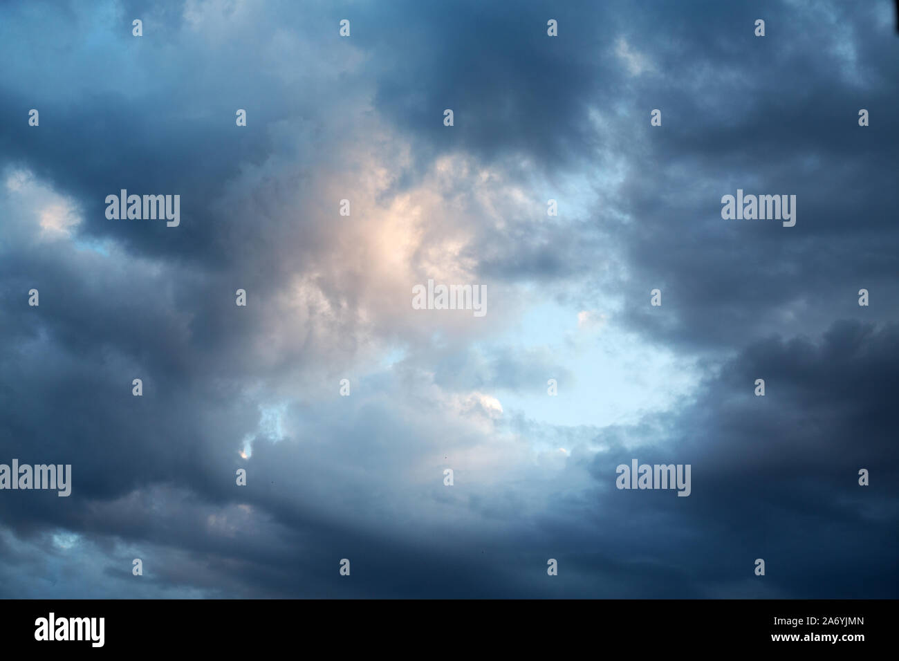 dark evening cumulus clouds in the setting sun Stock Photo