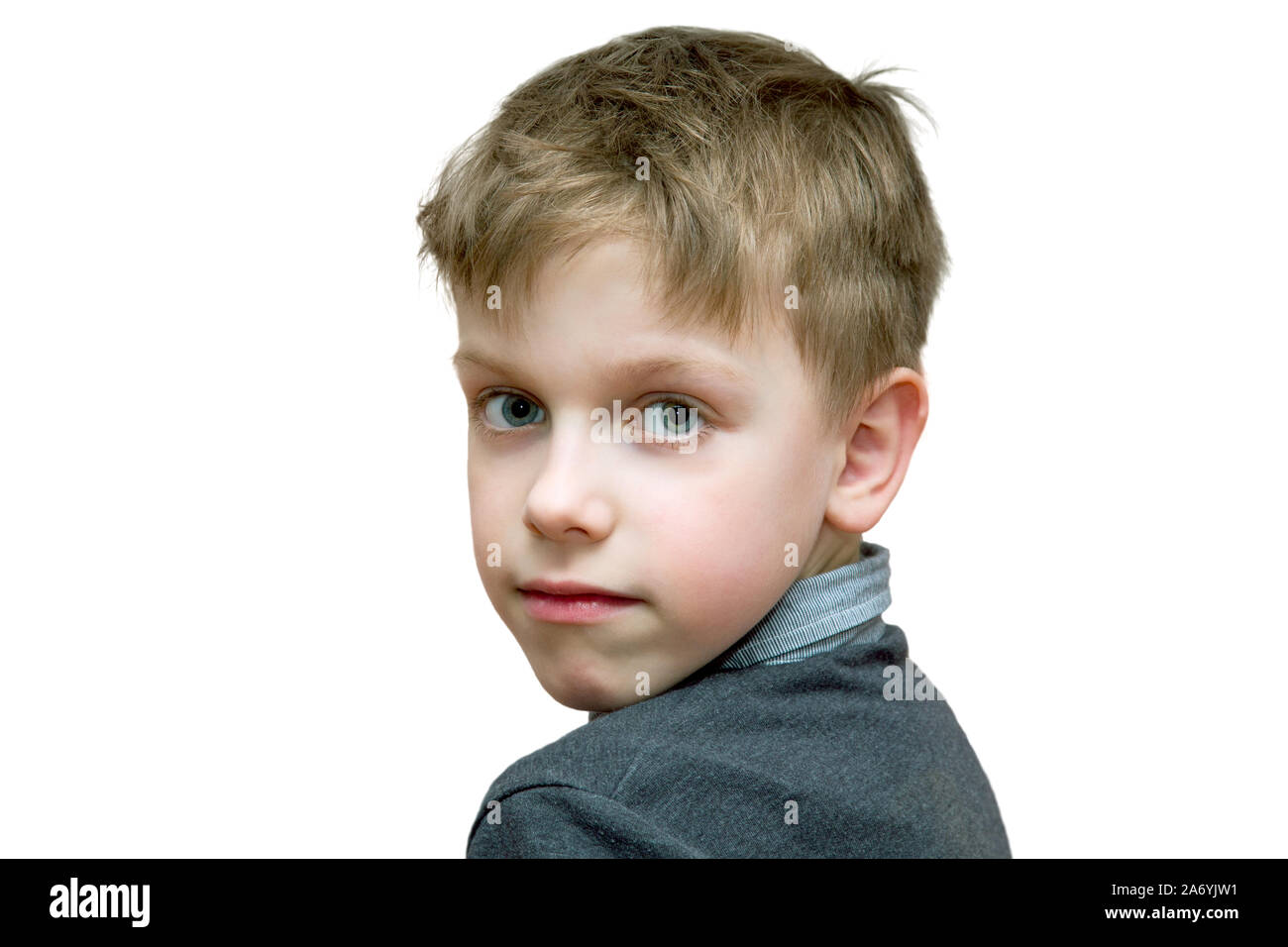 the boy looks half-turned right into the camera on a white background Stock Photo