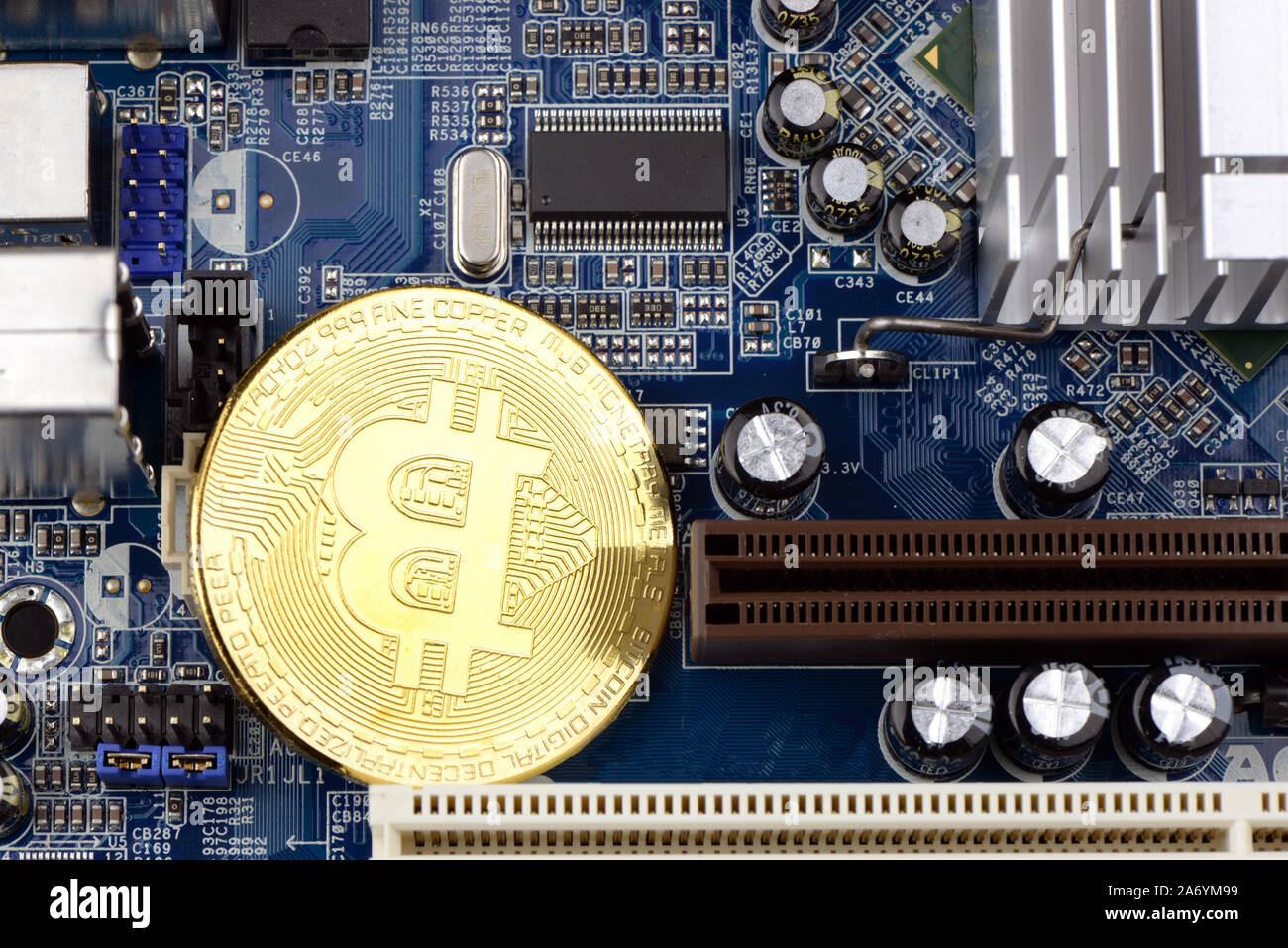 Golden Cryptocurrency coins on computer circuit board - image Stock Photo