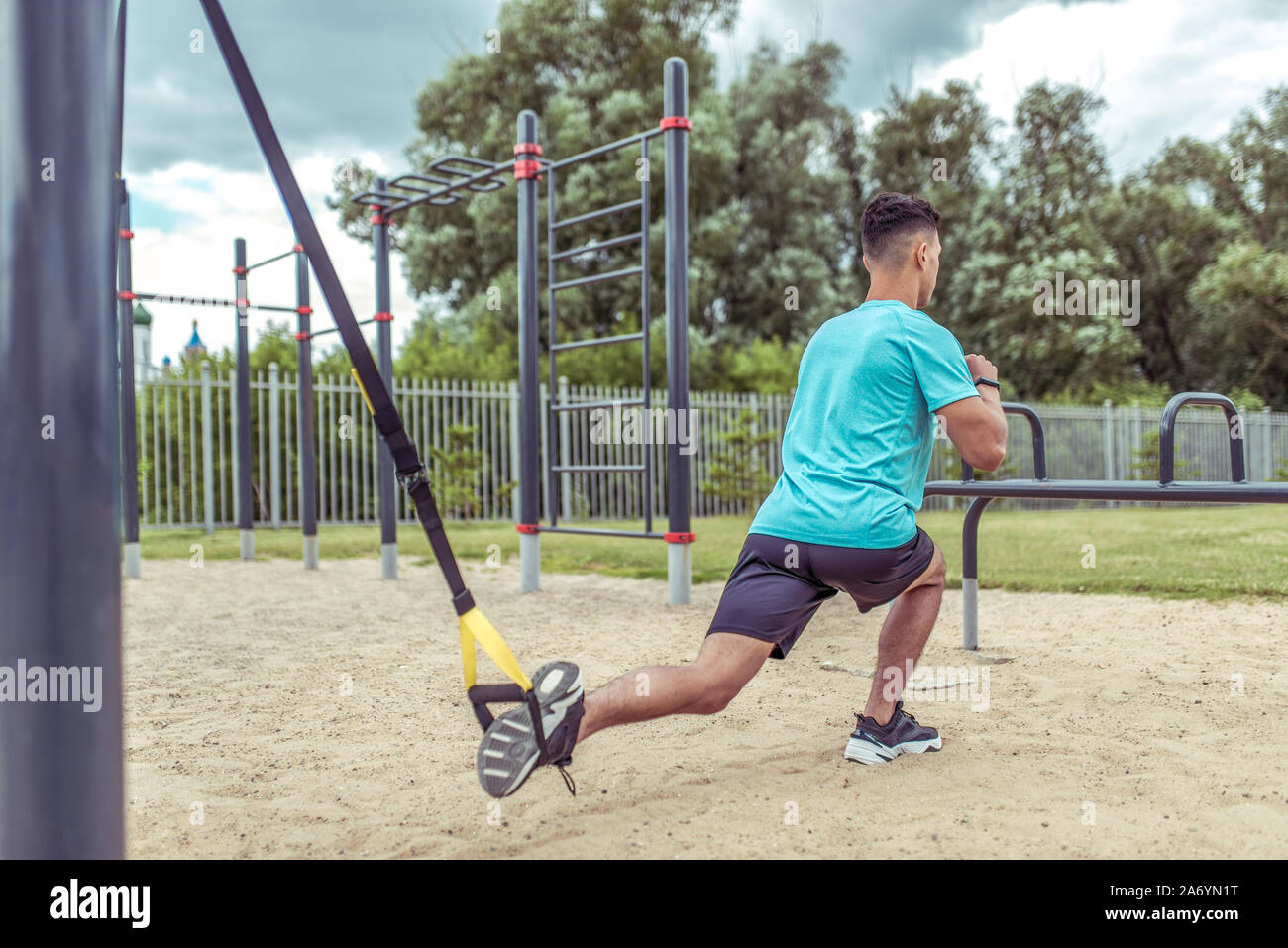 Athletic man exercises with straps loops trx, lunges workout leg