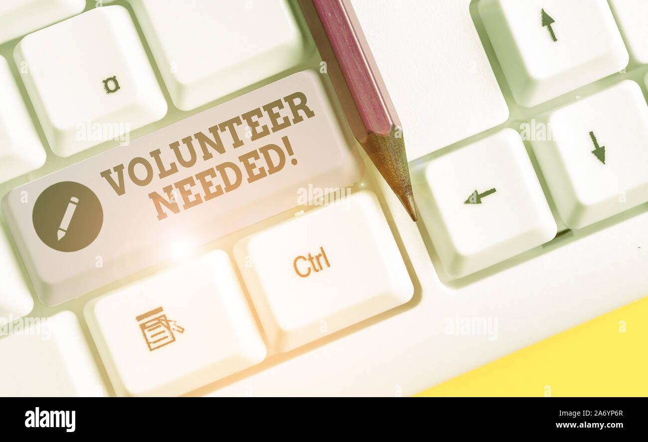 Text sign showing Volunteer Needed. Business photo text need work for organization without being paid White pc keyboard with empty note paper above wh Stock Photo