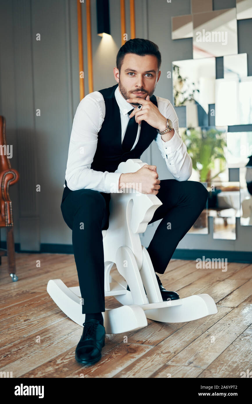 Man Riding Rocking Horse Adult man ride wooden rocking horse. Fun concept Stock Photo - Alamy