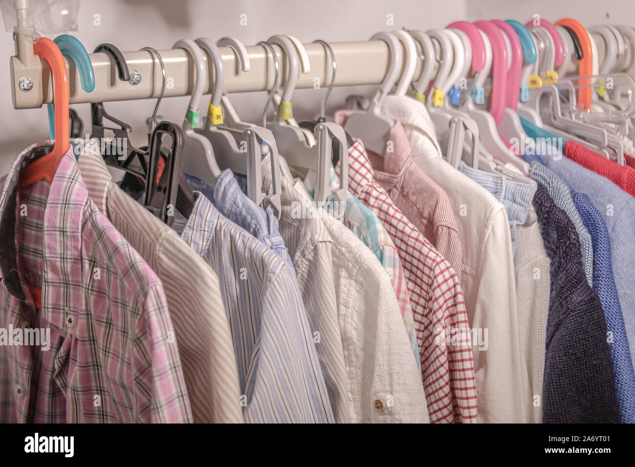 Hangers with children's clothes hanging on a stand in a closet Stock Photo