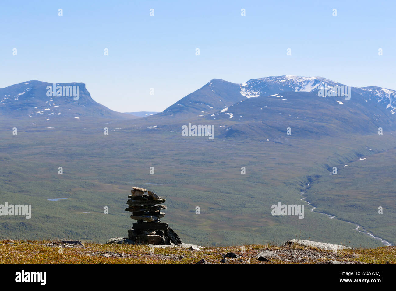 View towards the U-shaped mountain Tjuonavagge with a small mound of stones in the foreground. Arctic region of Sweden. Stock Photo