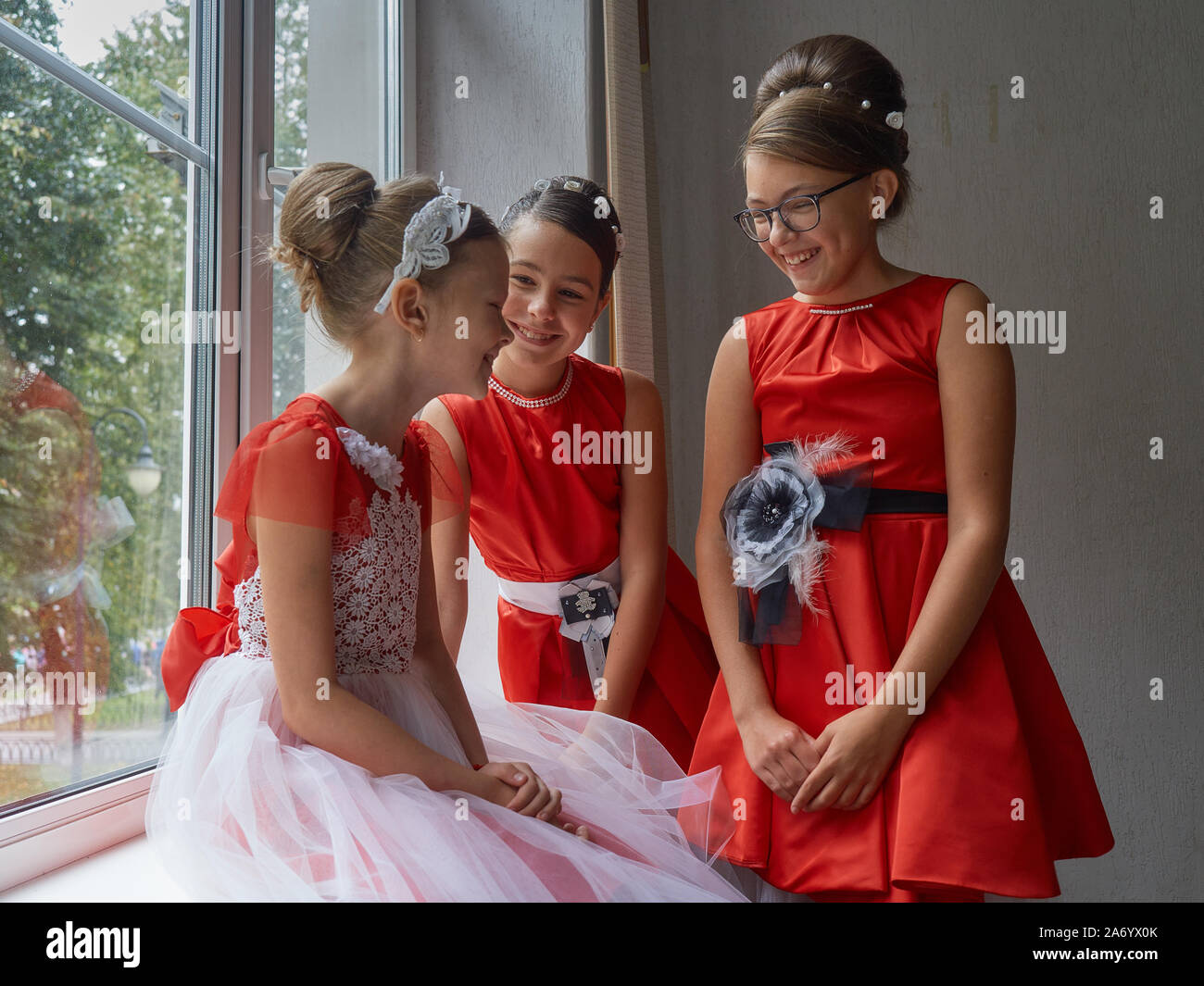 Vitebsk-Belarus. Eastern Europe-September 19, 2019: Three girls under the  age of 15 years dressed in bright red evening dresses communicate during a  b Stock Photo - Alamy