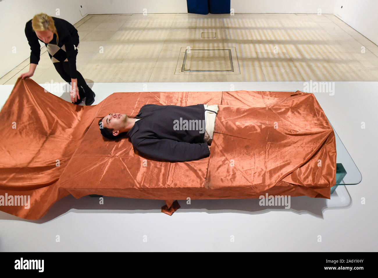 London, UK.  29 October 2019. A staff member experiences 'Shroud/Chrysalis I' by Catherine Richards, a copper sheet that cuts out mobile phone signals.  Preview of '24/7: A Wake-Up Call For Our Non-Stop World', a new exhibition opening on 31 October at Somerset House.  The show examines our inability to switch off from our 24/7 culture.  Over 50 multi-disciplinary works explore the pressure to produce and consume information around the clock. taking visitors on a 24-hour cycle from dawn to dusk through interactive installations.  Credit: Stephen Chung / Alamy Live News Stock Photo